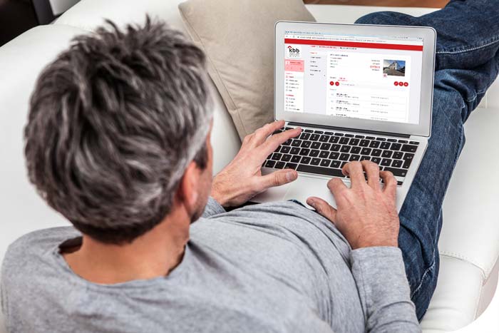 Mann mit Laptop auf dem Schoß surft im Kundenportal